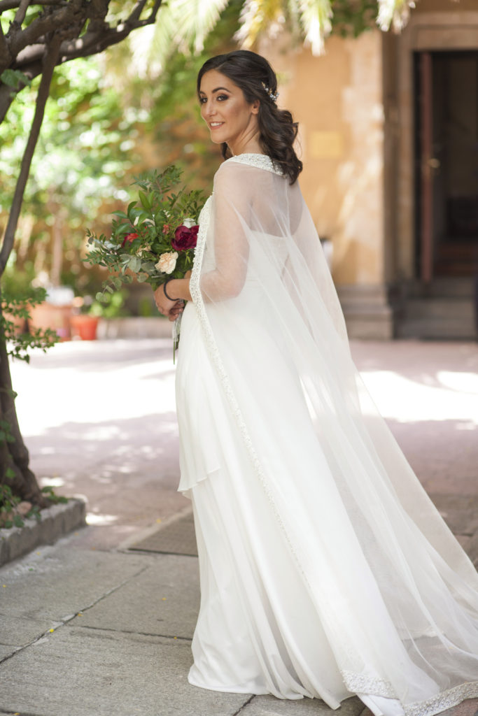 Bride wearing a strapless dress with a bridal cape